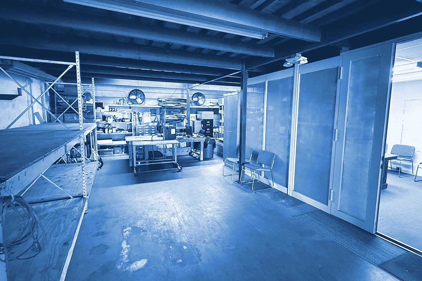 The warehouse floor with racking and a workbench